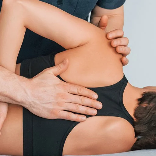 Chiropractor adjusting a person's shoulder and back